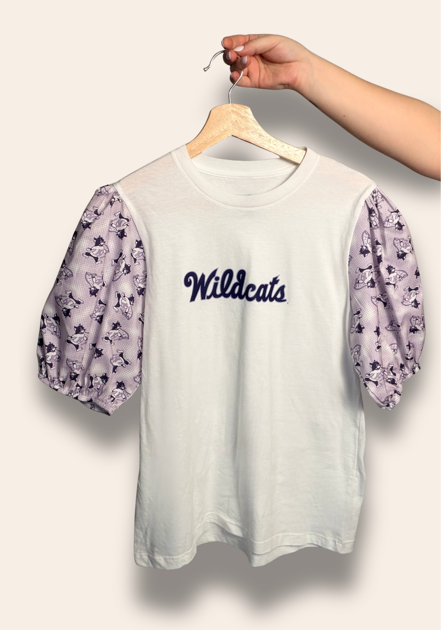Soft, sweet, and full of Wildcat pride.
Our Wildcats Script Puff Tee features delicate lavender puff sleeves with playful Wildcat details and a classic script front that feels timeless and feminine. It’s the perfect elevated game day look for cheering on K-State, strolling campus, or repping your Wildcats wherever you go.
Comfortable, flattering, and made for the cutest fan in purple.