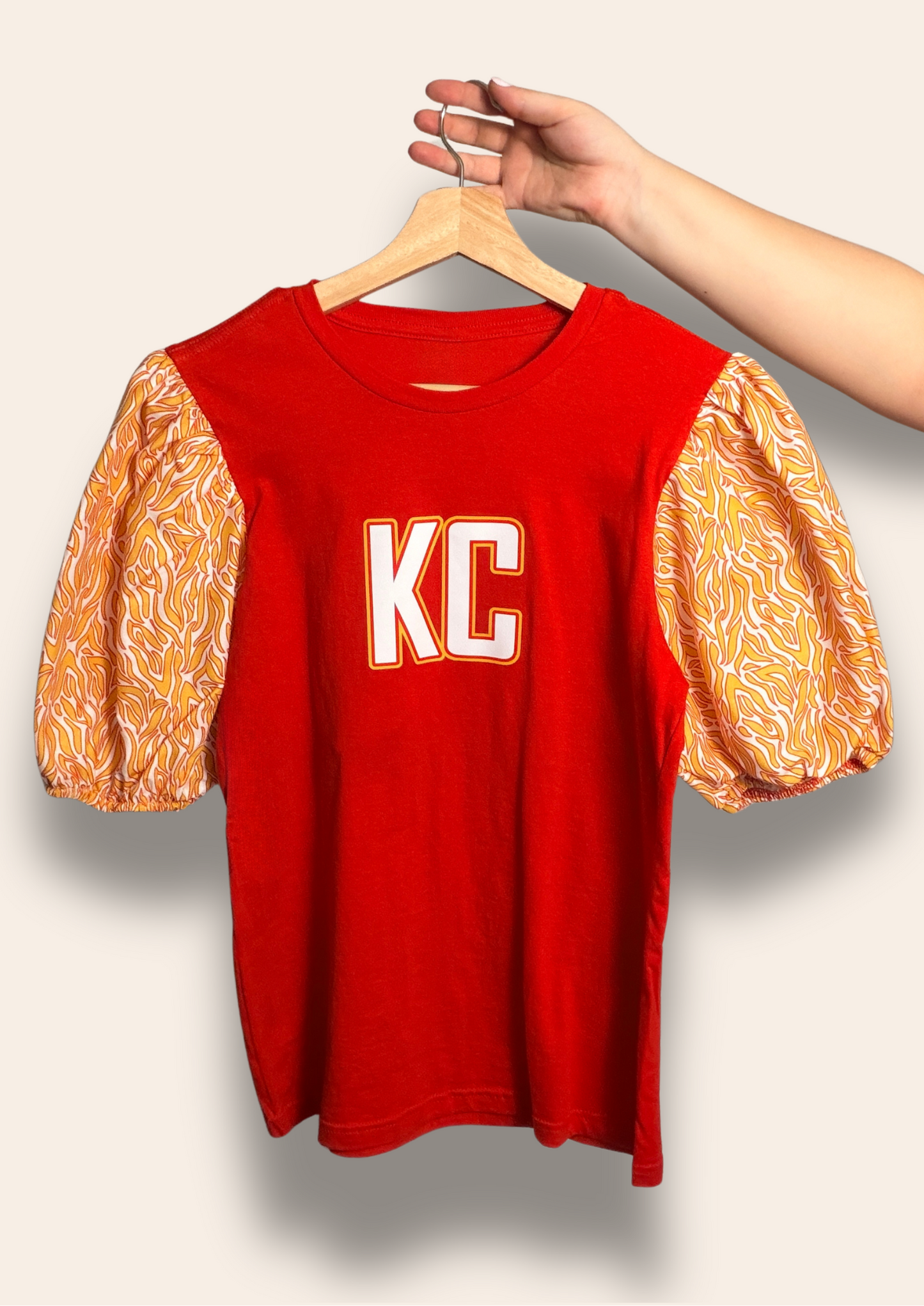 For the girls who bring electric energy to the Kingdom.
Our KC Kingdom Electric Puff Tee features a bold red base with vibrant gold statement puff sleeves inspired by the iconic Chiefs colors. Feminine, fierce, and made to stand out, it’s the perfect look for tailgates, touchdowns, and cheering on Kansas City in style.
Comfortable, flattering, and made for your game day era.