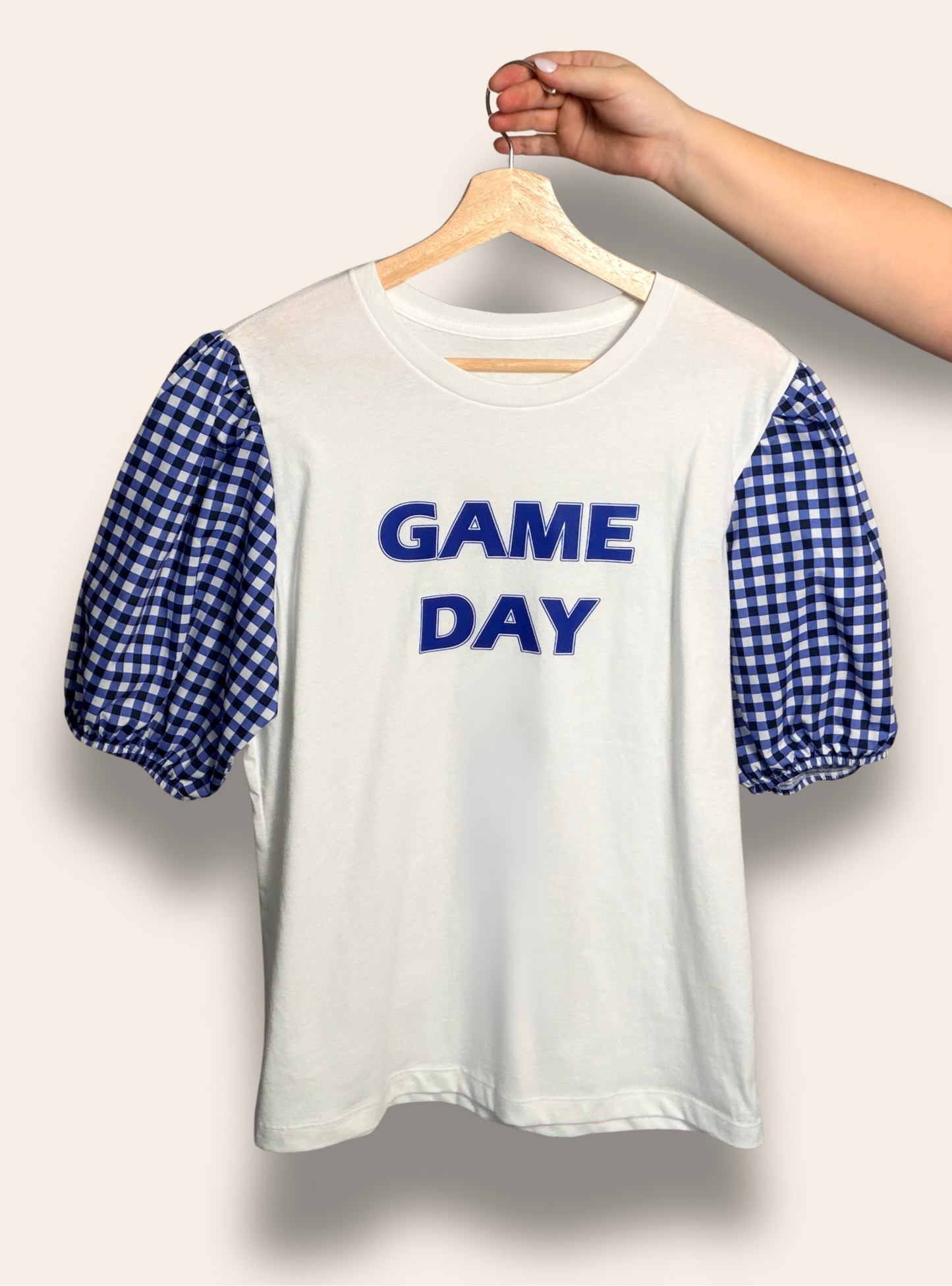 Because game day deserves a cute outfit.

Our Game Day Darling Puff Tee features a classic white base with bold blue lettering and the sweetest blue gingham puff sleeves. Feminine, fun, and effortlessly elevated, it’s perfect for cheering on your team, tailgates, and every game day moment.

Comfortable, flattering, and made for the cutest fan in the stands.